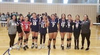 a group of volleyball players posing for a picture