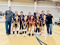 a group of volleyball players posing for a picture