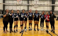 a group of volleyball players posing for a picture