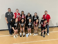 a group of girls posing for a picture on a court