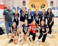 a group of volleyball players posing for a picture